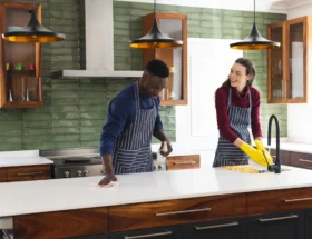 Une femme et un homme qui nettoie une cuisine