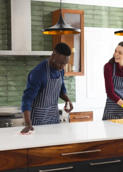 Une femme et un homme qui nettoie une cuisine