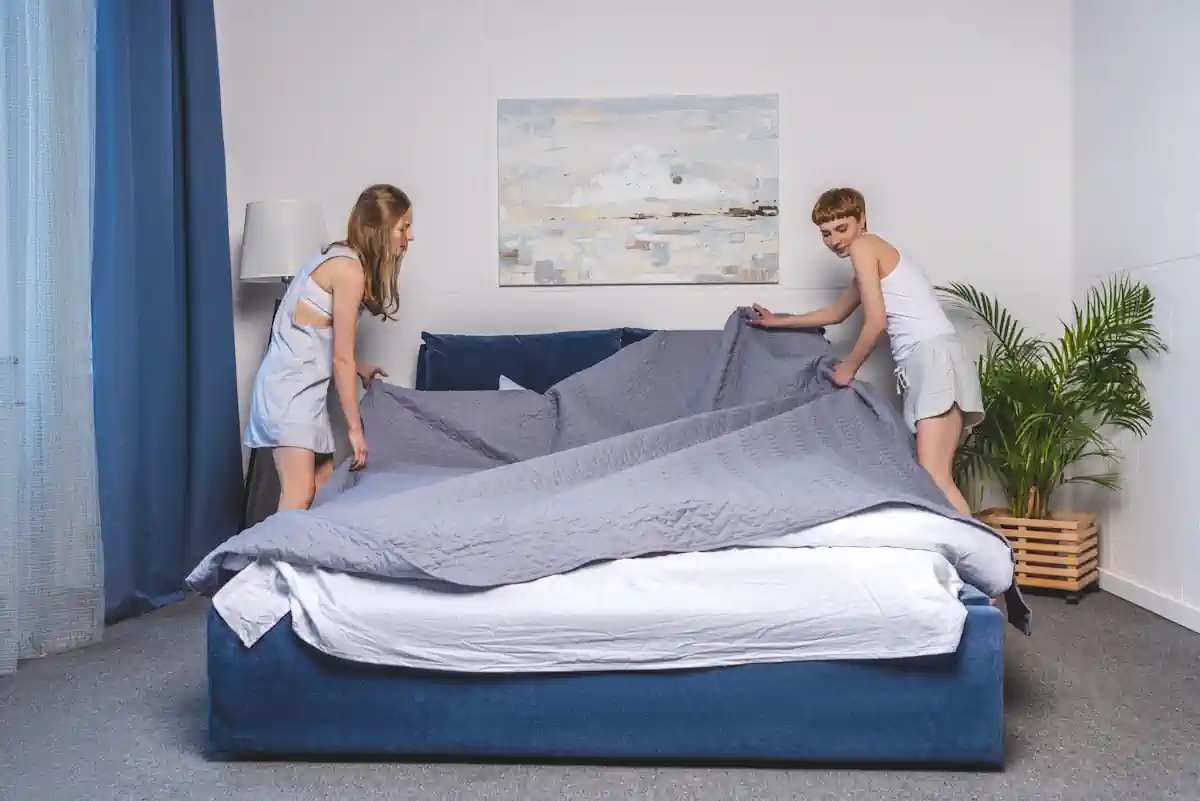 Deux femmes qui mettent une parure sur le lit