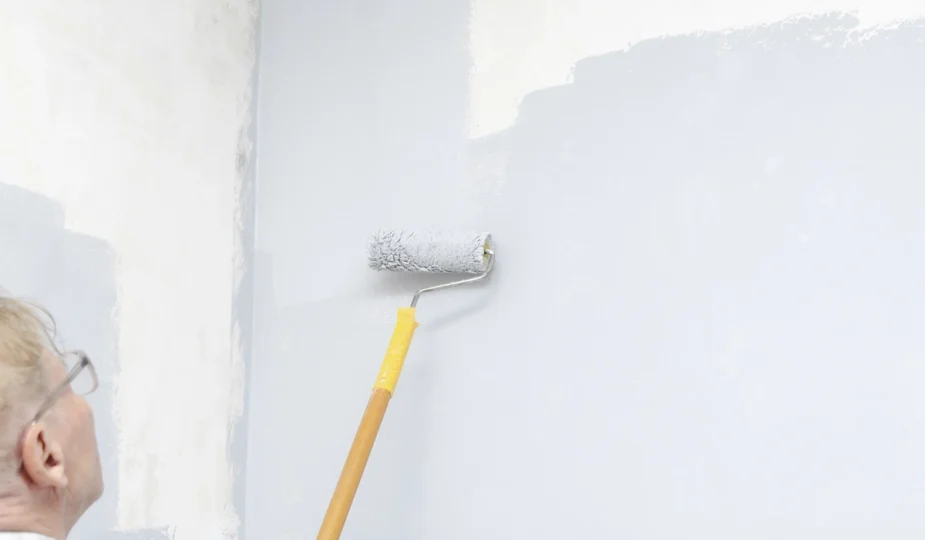 Une personne qui applique une sous-couche sur un mur