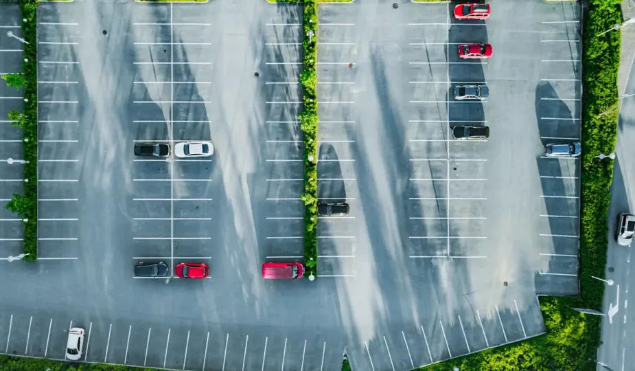 Un parking avec de la verdure et quelques voitures installées