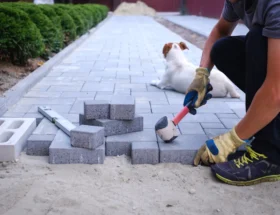 Un homme qui pose une pavée extérieure
