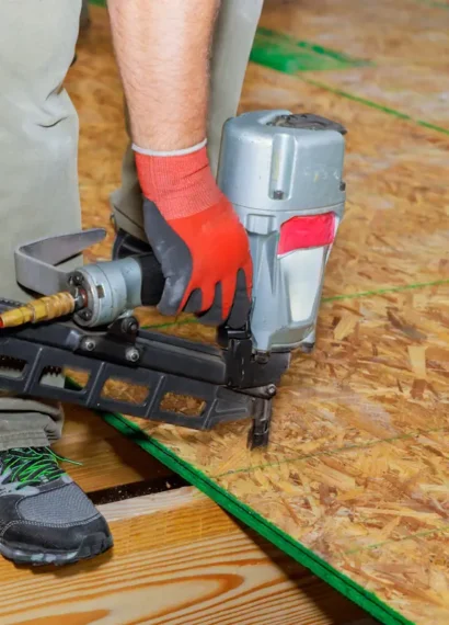 Un homme qui installe des panneaux osb