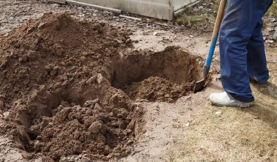 Un homme qui creuse un trou dans un jardin