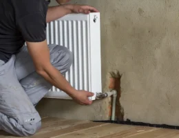 Un homme qui ferme un radiateur mural