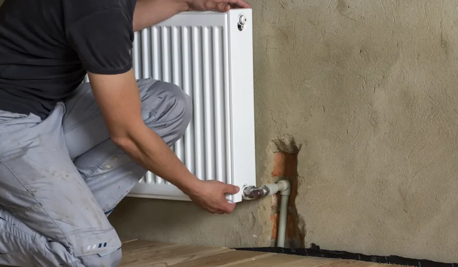 Un homme qui ferme un radiateur mural