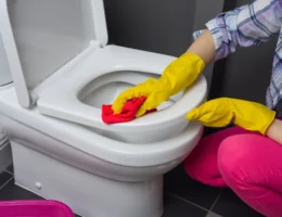 Une femme qui nettoie les toilettes