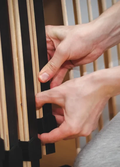 Une personne qui tient un meuble en bambou noirci