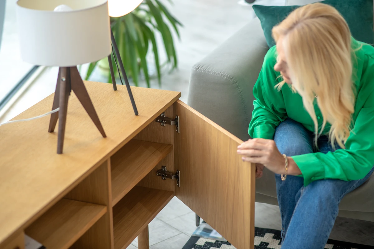 Une femme qui regarde un meuble en mérisier
