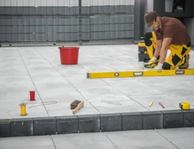 Un homme qui créé un garage en plaque béton