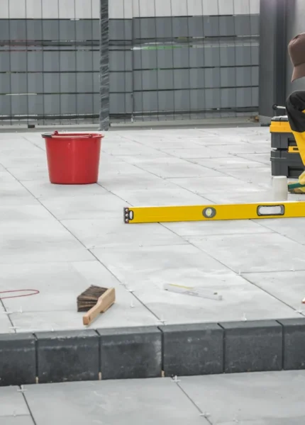 Un homme qui créé un garage en plaque béton