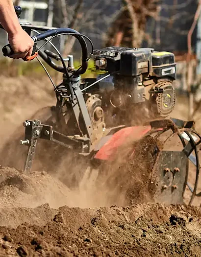 Un homme qui travaille avec un motoculteur