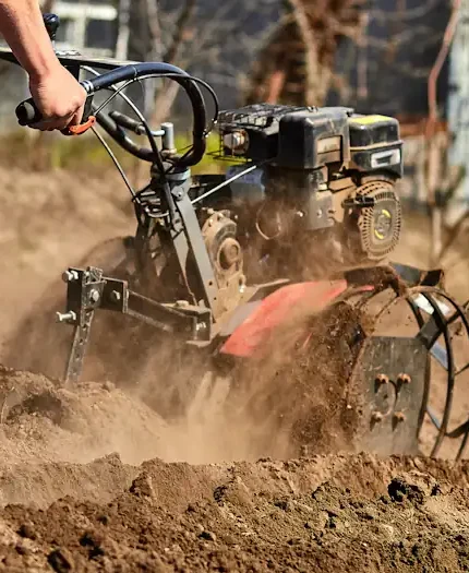 Un homme qui travaille avec un motoculteur