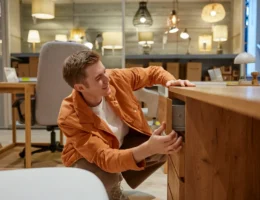 Un homme qui regarde un meuble en mérisier