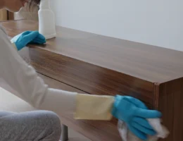 Une personne qui nettoie un meuble en bambou noirci