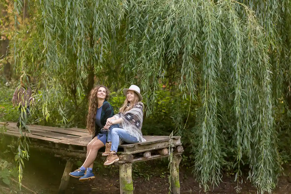 Deux jeunes femmes qui s'abrite sous un saule pleureur