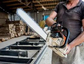 Un homme qui tient une tronçonneuse électrique