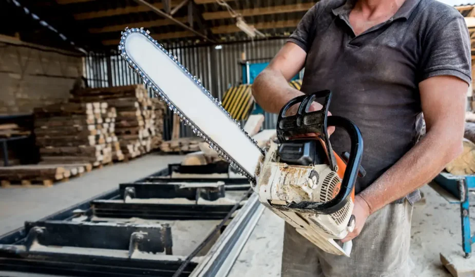 Un homme qui tient une tronçonneuse électrique