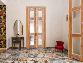 Charming vintage room with distressed wooden doors and graphic patterned floor.