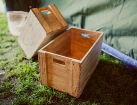 Rustic wooden crates placed on grass in a rural outdoor setting, perfect for garden decor.