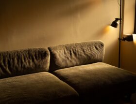 A corduroy sofa in a dimly lit room with a warm and inviting atmosphere.