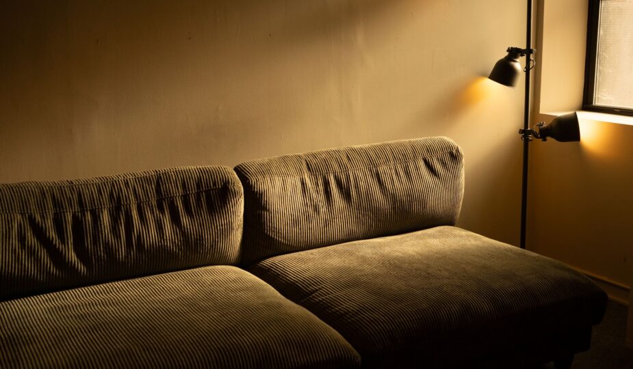 A corduroy sofa in a dimly lit room with a warm and inviting atmosphere.