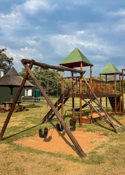 Empty wooden playground outdoors under sunny skies, ideal for kids' activities.