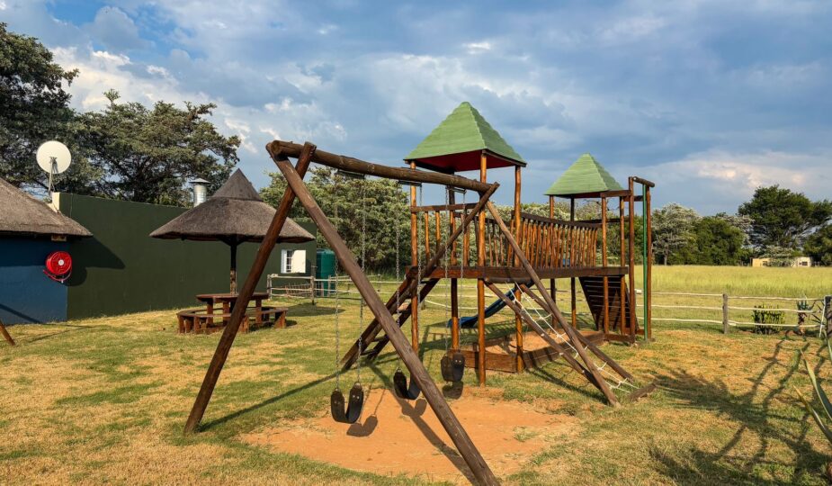 Empty wooden playground outdoors under sunny skies, ideal for kids' activities.