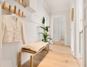 Bright minimalist hallway featuring wooden furniture and a stylish coat rack.