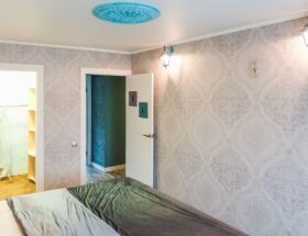 A bright and modern bedroom showcasing elegant wallpaper and sleek decor elements.