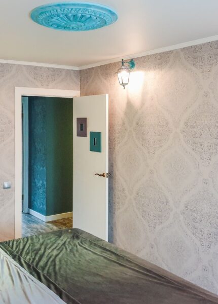 A bright and modern bedroom showcasing elegant wallpaper and sleek decor elements.