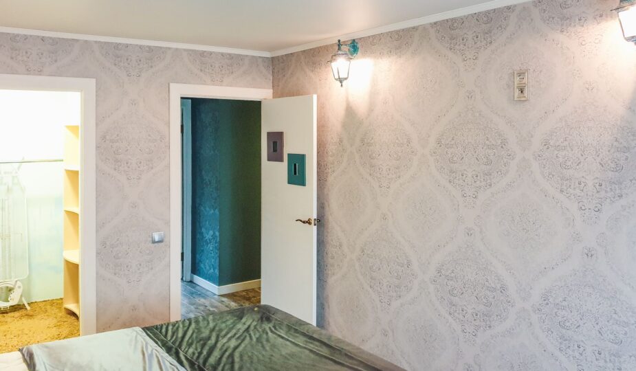 A bright and modern bedroom showcasing elegant wallpaper and sleek decor elements.