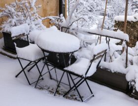 Charming outdoor patio covered in fresh snow, creating a serene winter wonderland.