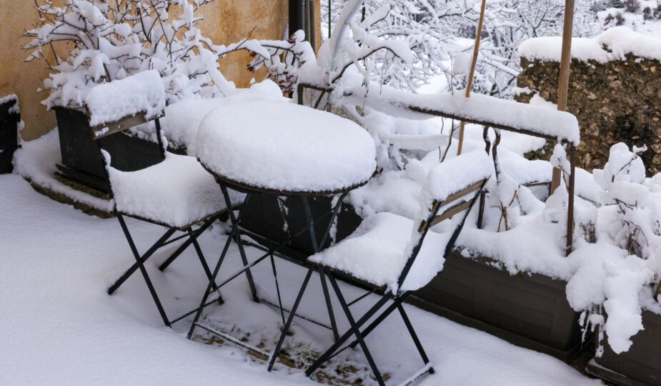 Charming outdoor patio covered in fresh snow, creating a serene winter wonderland.