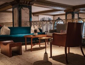 Cozy and elegant lounge area featuring velvet sofa and stylish armchairs.