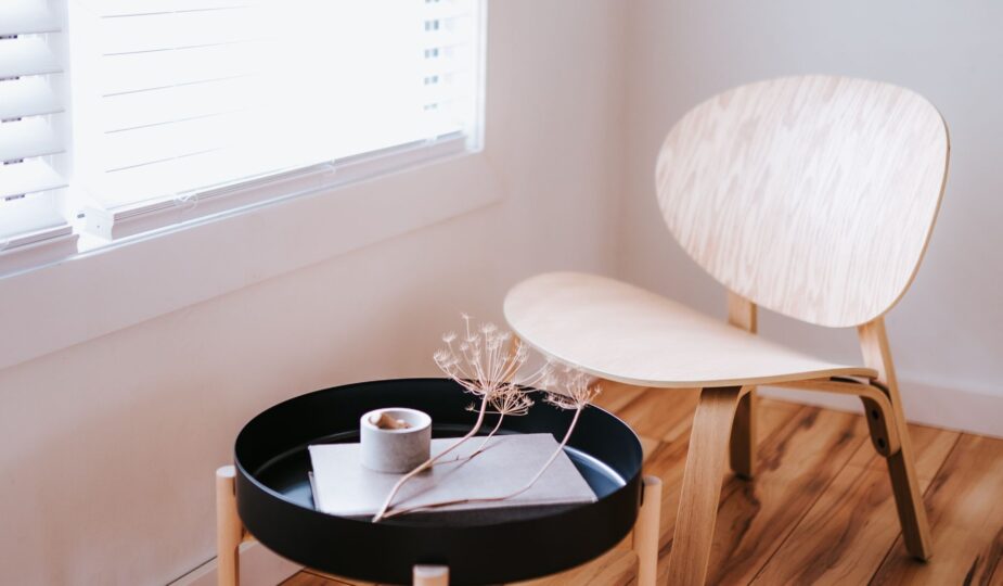 Elegant Japandi style room with a wooden chair, round table, and decorative items.