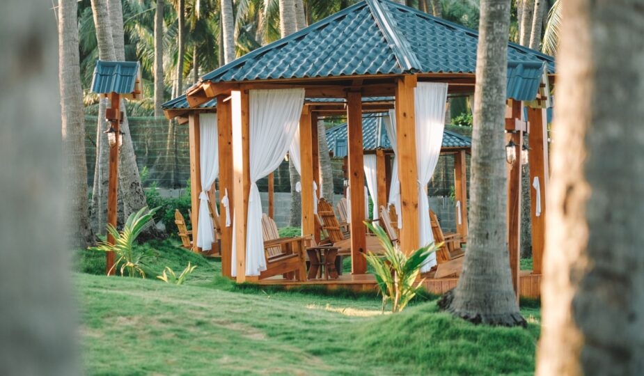 A serene wooden gazebo amidst palm trees in Phan Thiet, Vietnam, ideal for relaxation.
